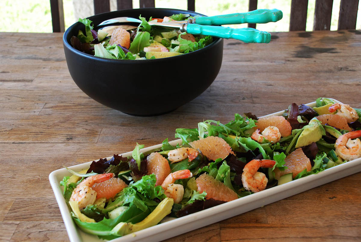 Shrimp Salad with Avocado & Grapefruit sitting on a wooden table